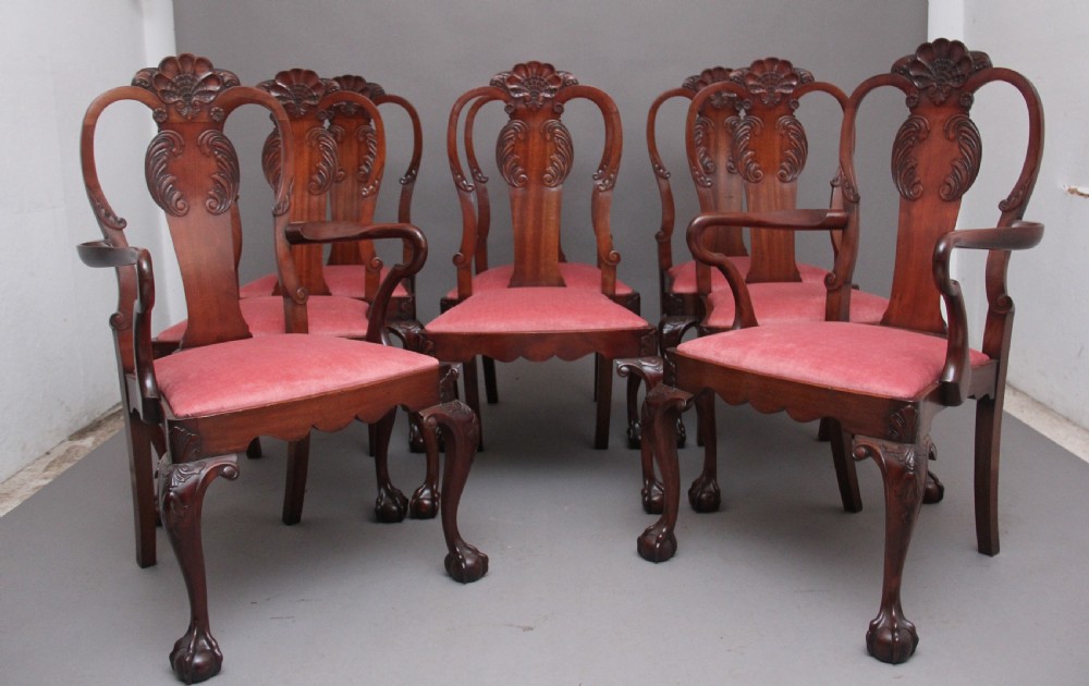 Set of eight 19th-century carved mahogany dining chairs featuring cabriole legs with ball and claw feet and red upholstered seats.