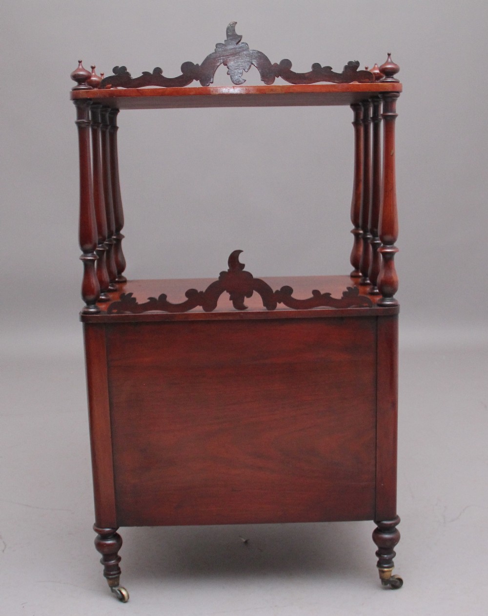 A 19th-century mahogany whatnot with open turned-spindle top shelf over three drawers raised on brass castors. View V