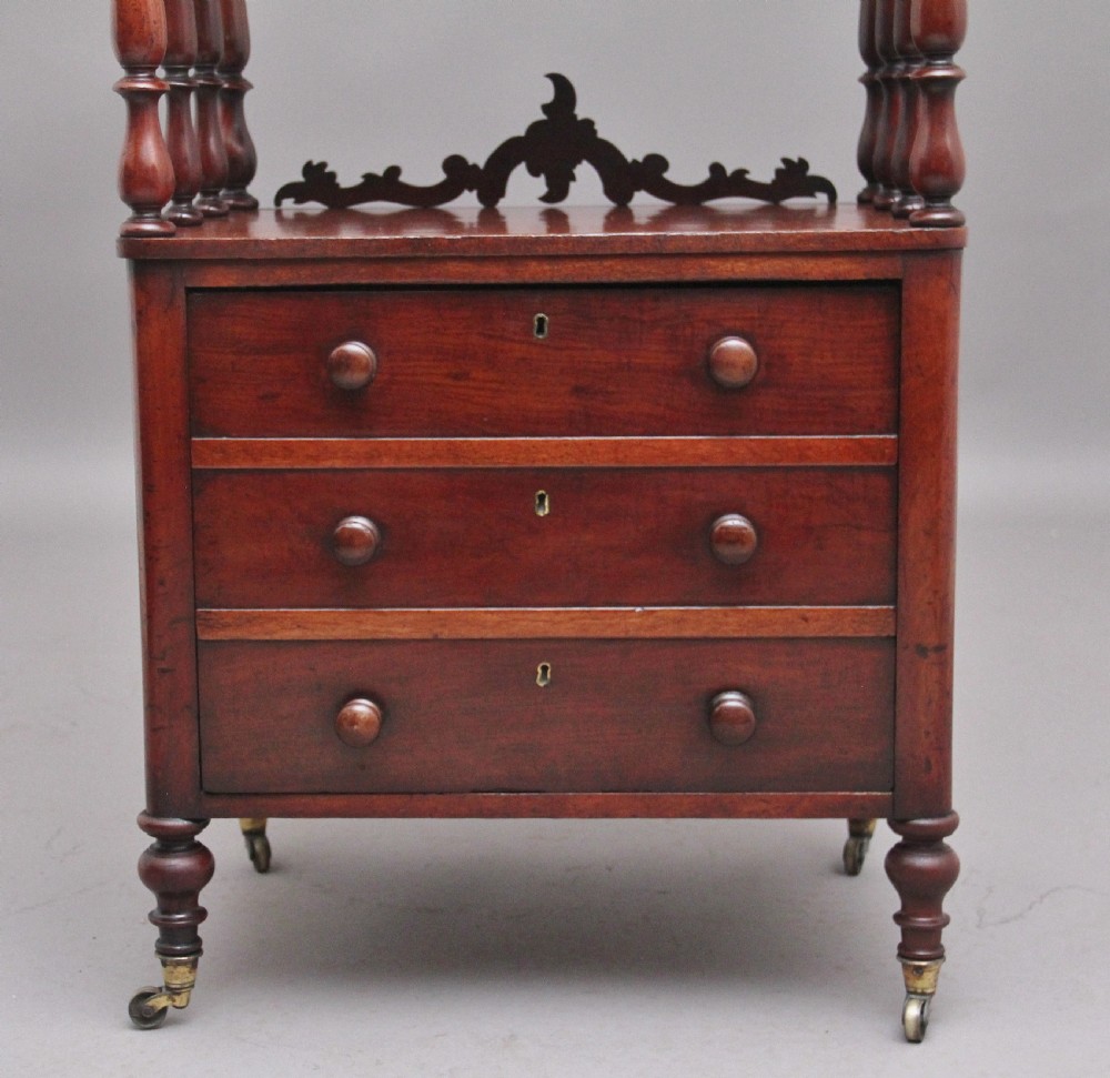 A 19th-century mahogany whatnot with open turned-spindle top shelf over three drawers raised on brass castors. View XI