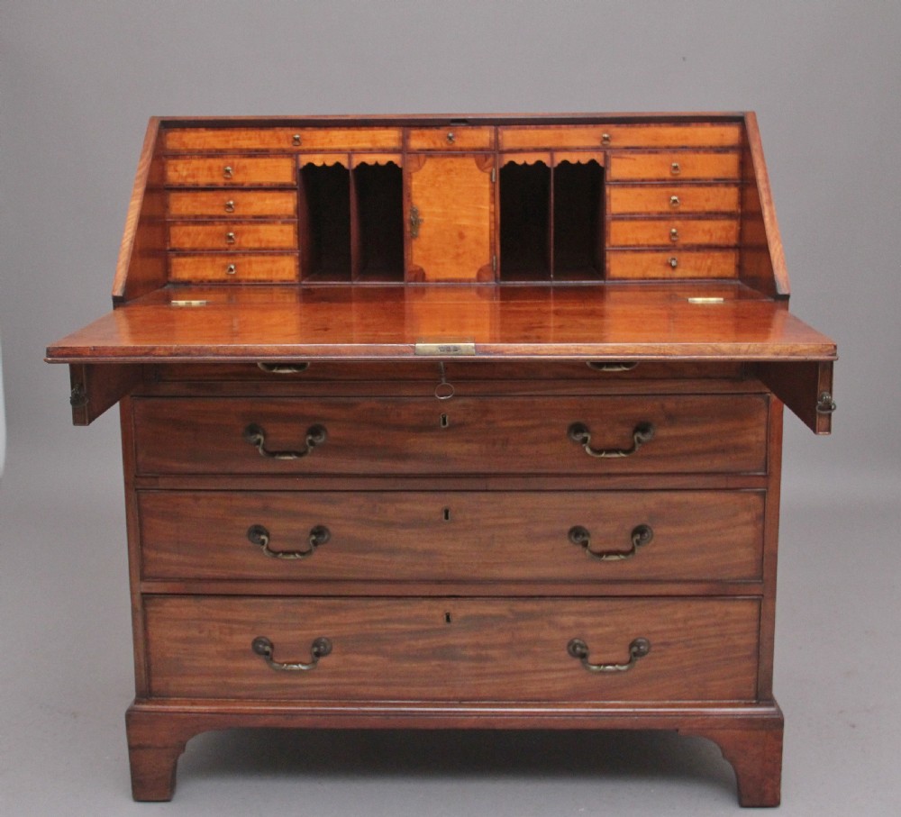 An eighteenth-century mahogany writing bureau featuring a slant-front slope above four graduated drawers with brass swan-neck handles and bracket feet. View II