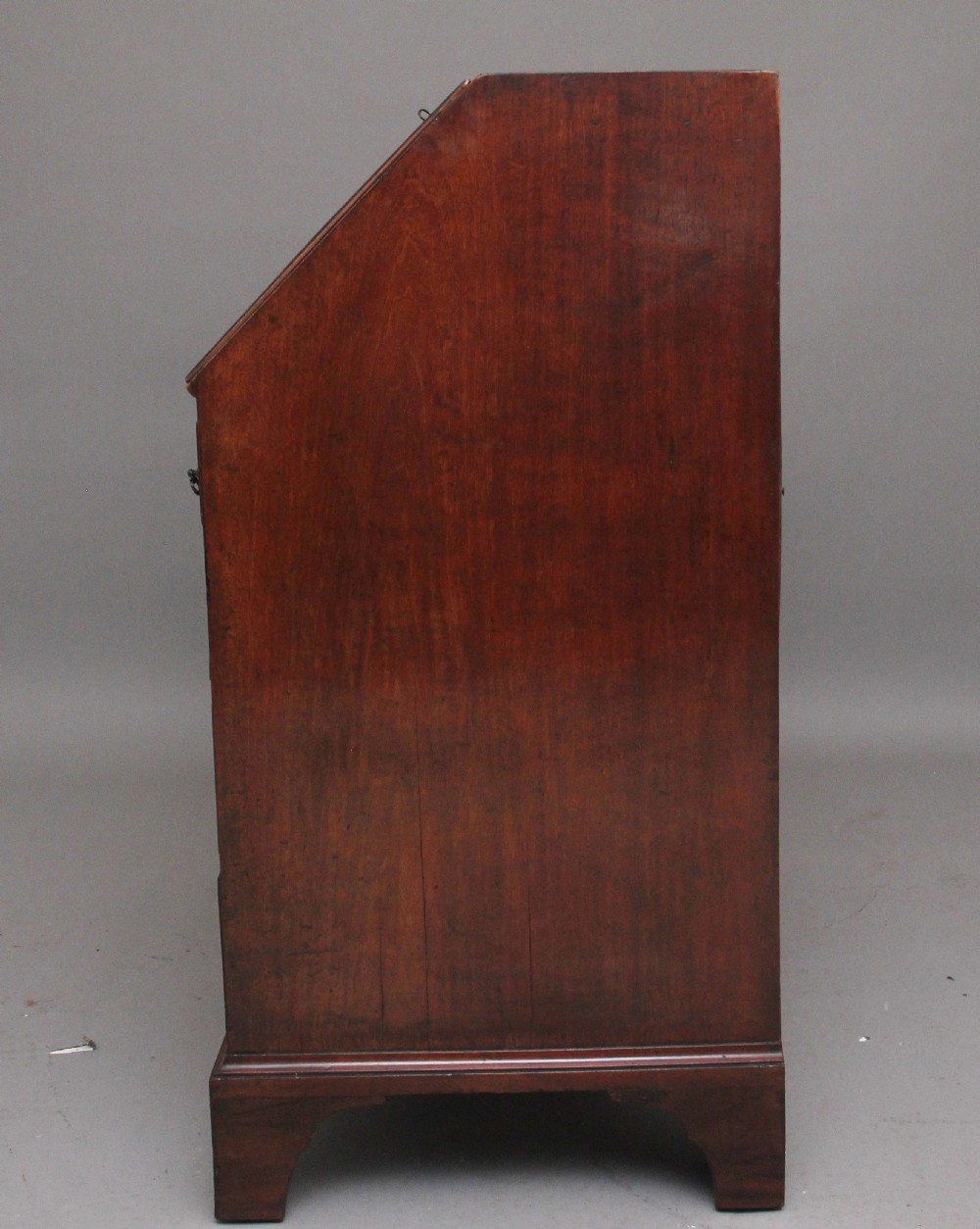An eighteenth-century mahogany writing bureau featuring a slant-front slope above four graduated drawers with brass swan-neck handles and bracket feet. View VIII