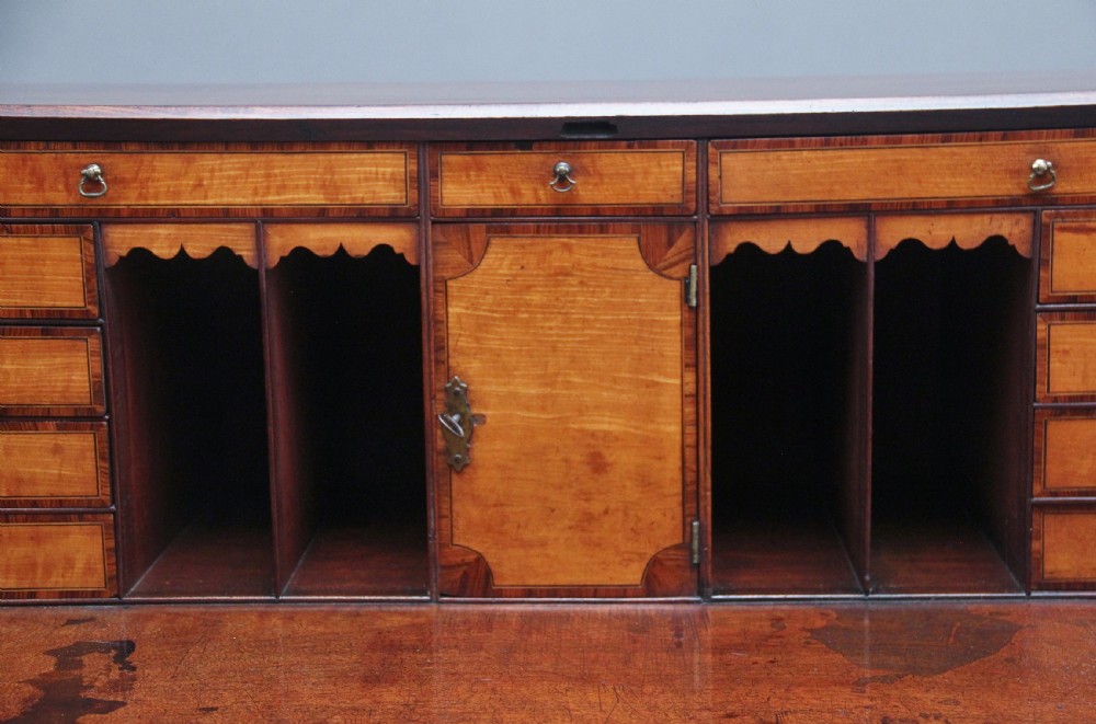 An eighteenth-century mahogany writing bureau featuring a slant-front slope above four graduated drawers with brass swan-neck handles and bracket feet. View XIII