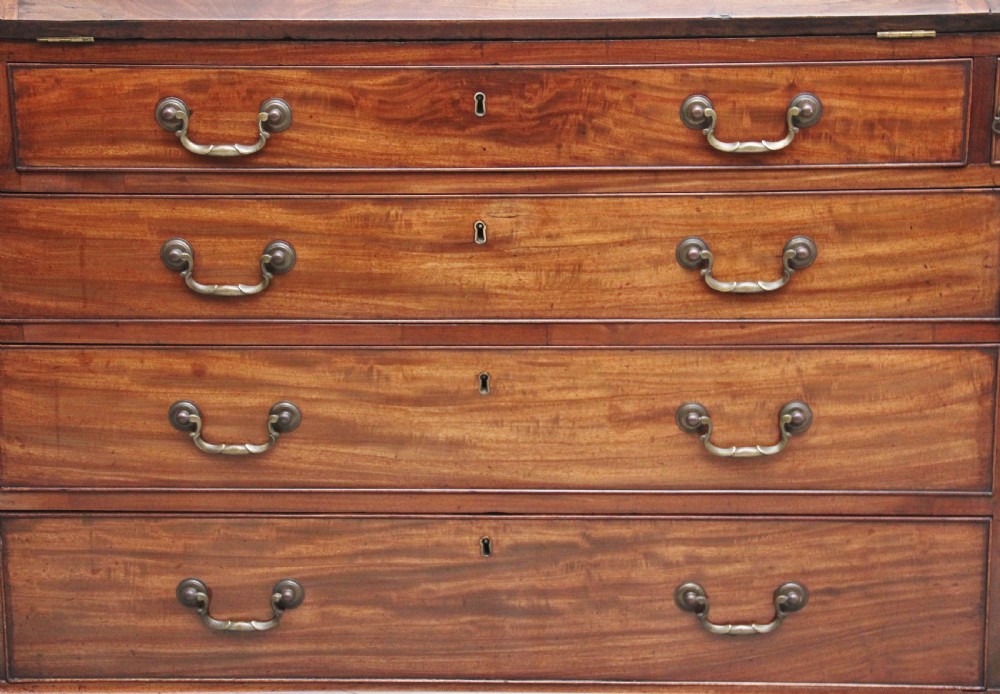 An eighteenth-century mahogany writing bureau featuring a slant-front slope above four graduated drawers with brass swan-neck handles and bracket feet. View XIV