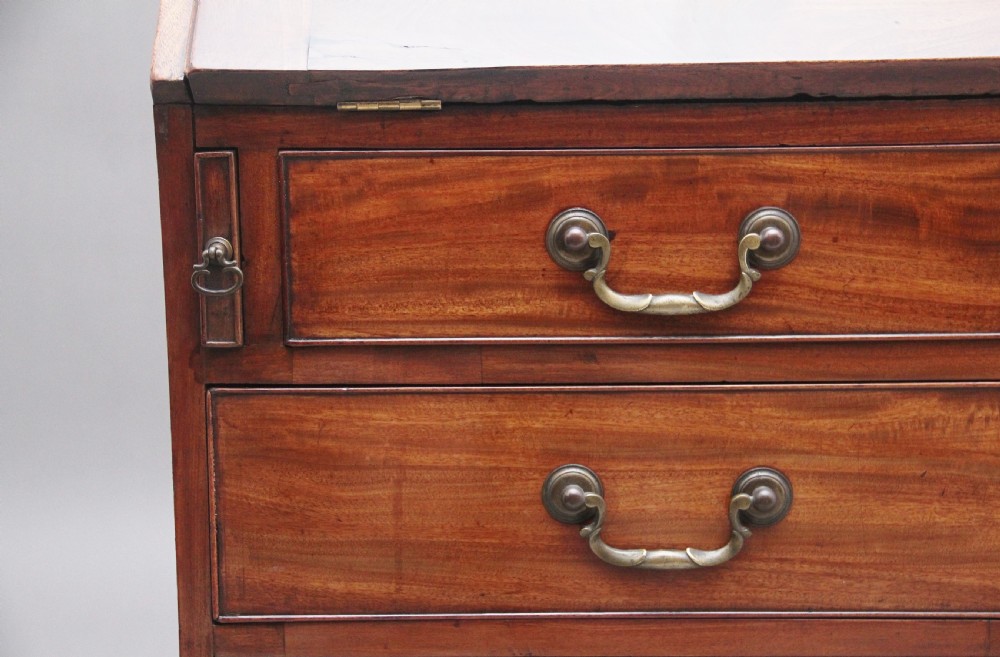 An eighteenth-century mahogany writing bureau featuring a slant-front slope above four graduated drawers with brass swan-neck handles and bracket feet. View XV