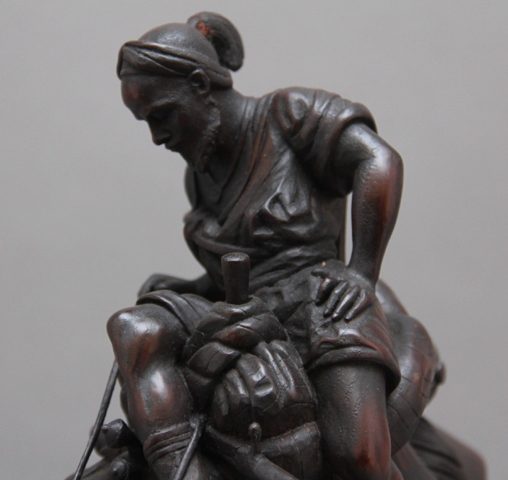 A 19th-century dark carved wood sculpture depicting a figure mounted on a striding camel upon an oval base. View XI