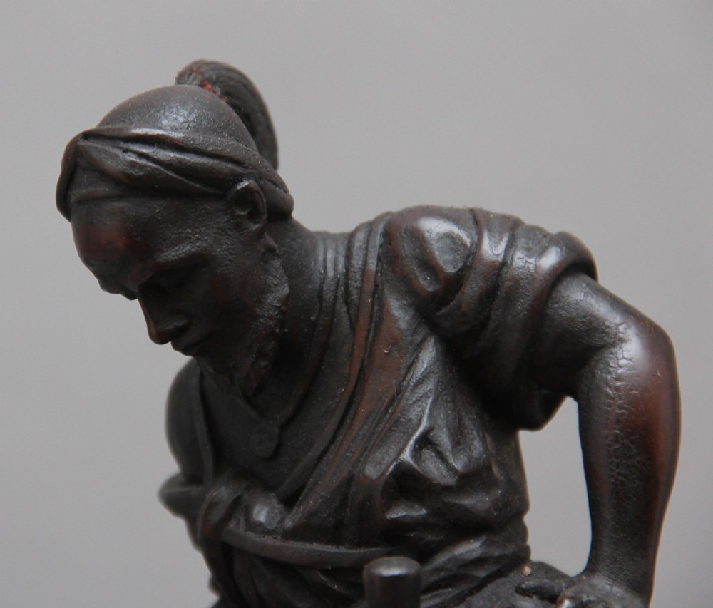 A 19th-century dark carved wood sculpture depicting a figure mounted on a striding camel upon an oval base. View XII