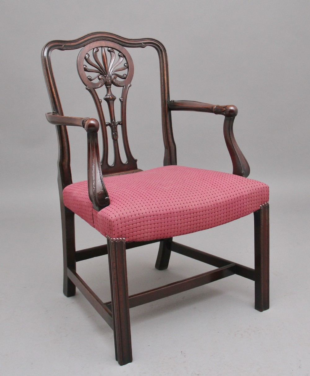 A set of dark mahogany dining armchairs featuring intricate anthemion carved back splats, curved arms, and pink patterned upholstered seats. View III