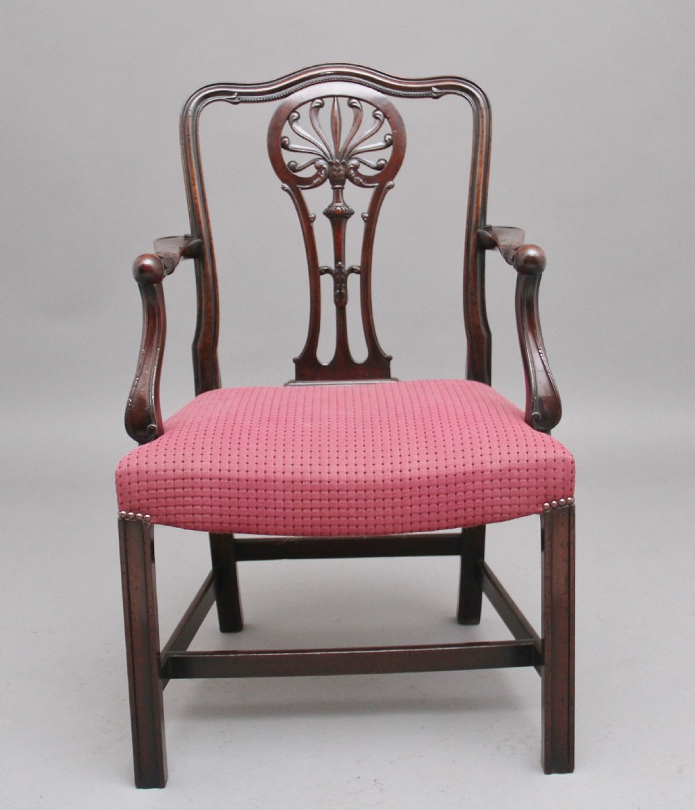 A set of dark mahogany dining armchairs featuring intricate anthemion carved back splats, curved arms, and pink patterned upholstered seats. View VIII
