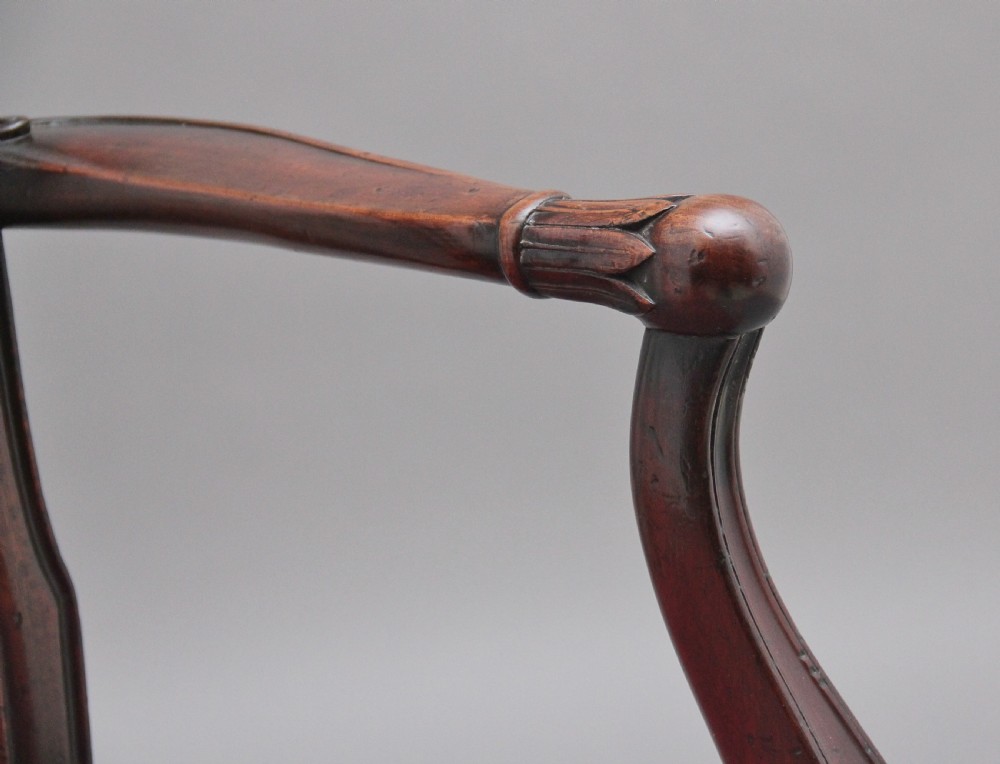 A set of dark mahogany dining armchairs featuring intricate anthemion carved back splats, curved arms, and pink patterned upholstered seats. View XII
