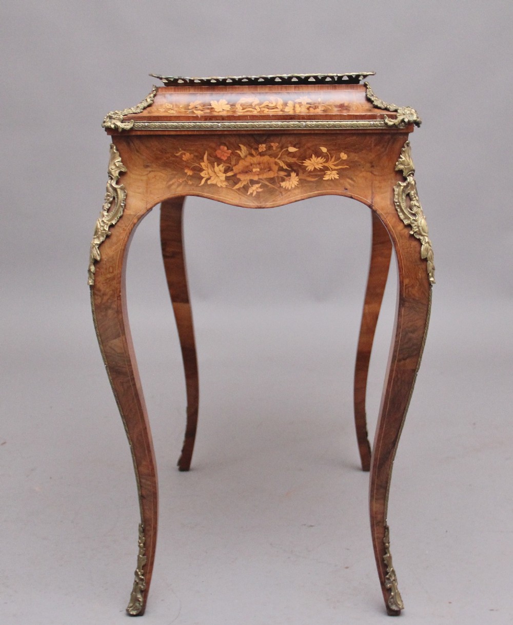 A 19th-century French Louis XV style burr walnut jardiniere table with floral marquetry inlay, brass gallery top, and gilt bronze mounts on cabriole legs. View XII