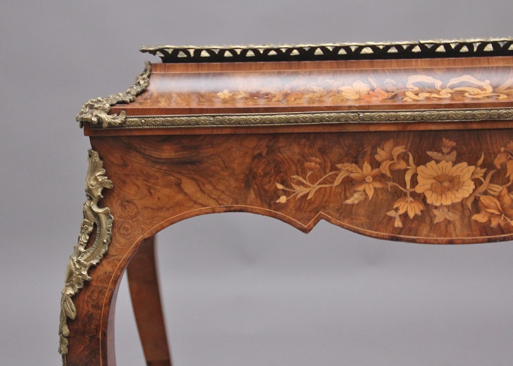 A 19th-century French Louis XV style burr walnut jardiniere table with floral marquetry inlay, brass gallery top, and gilt bronze mounts on cabriole legs. View XIII