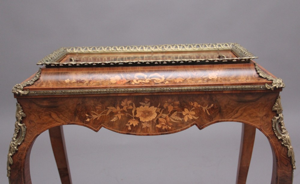 A 19th-century French Louis XV style burr walnut jardiniere table with floral marquetry inlay, brass gallery top, and gilt bronze mounts on cabriole legs. View XIV