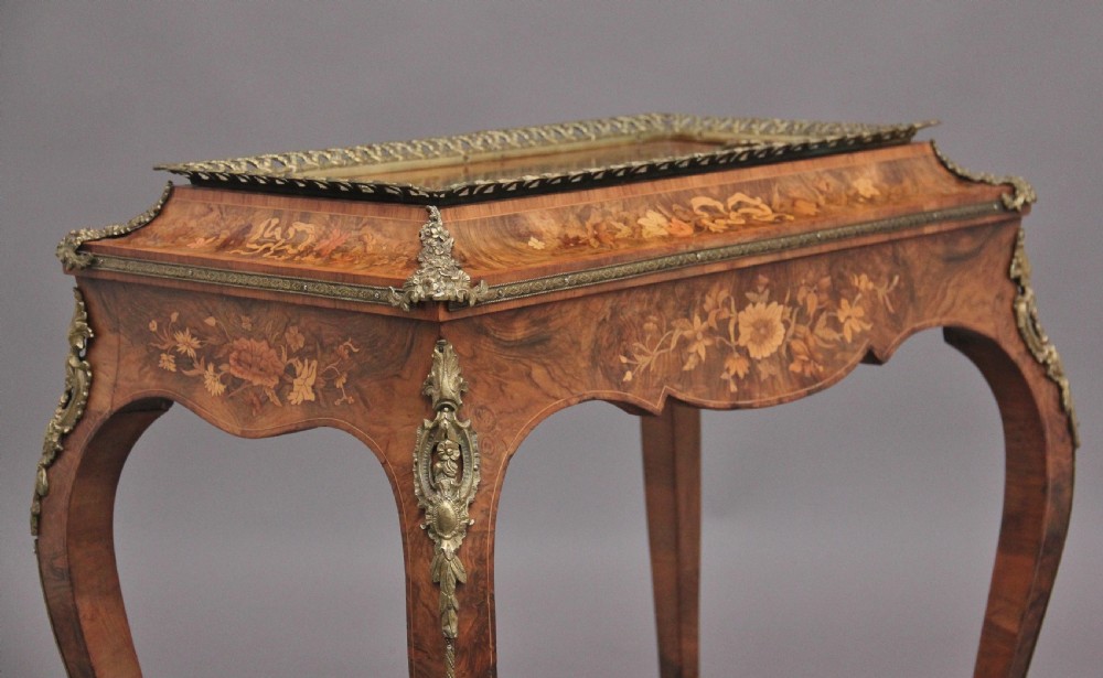 A 19th-century French Louis XV style burr walnut jardiniere table with floral marquetry inlay, brass gallery top, and gilt bronze mounts on cabriole legs. View XVII