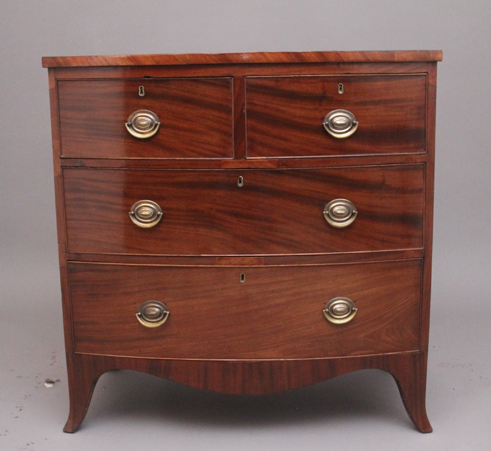 A 19th-century mahogany bowfront chest of drawers featuring two short drawers above two long drawers with oval brass handles and splayed bracket feet.