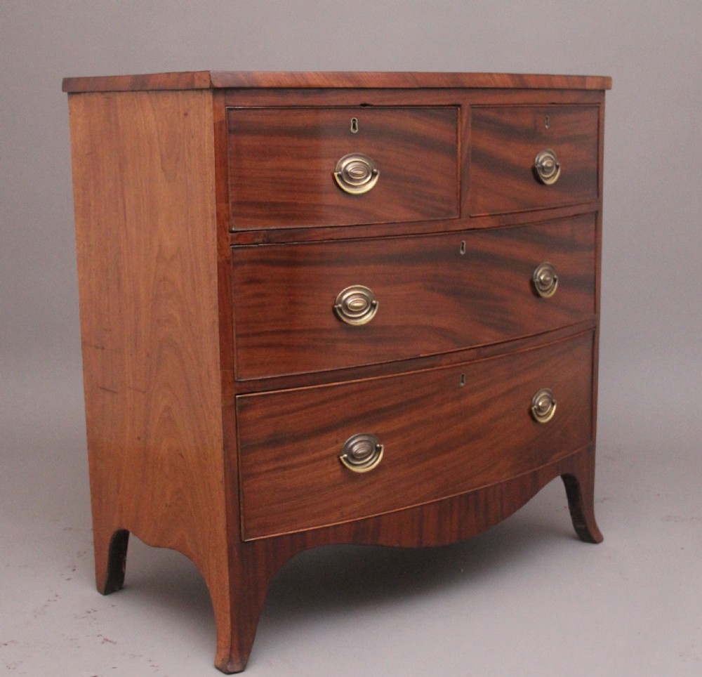 A 19th-century mahogany bowfront chest of drawers featuring two short drawers above two long drawers with oval brass handles and splayed bracket feet. View II