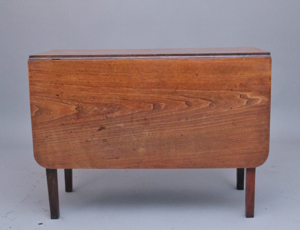 A 19th-century warm brown elm drop-leaf table featuring two hinged side flaps and straight wooden legs. View II