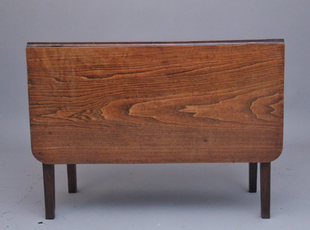 A 19th-century warm brown elm drop-leaf table featuring two hinged side flaps and straight wooden legs. View IV