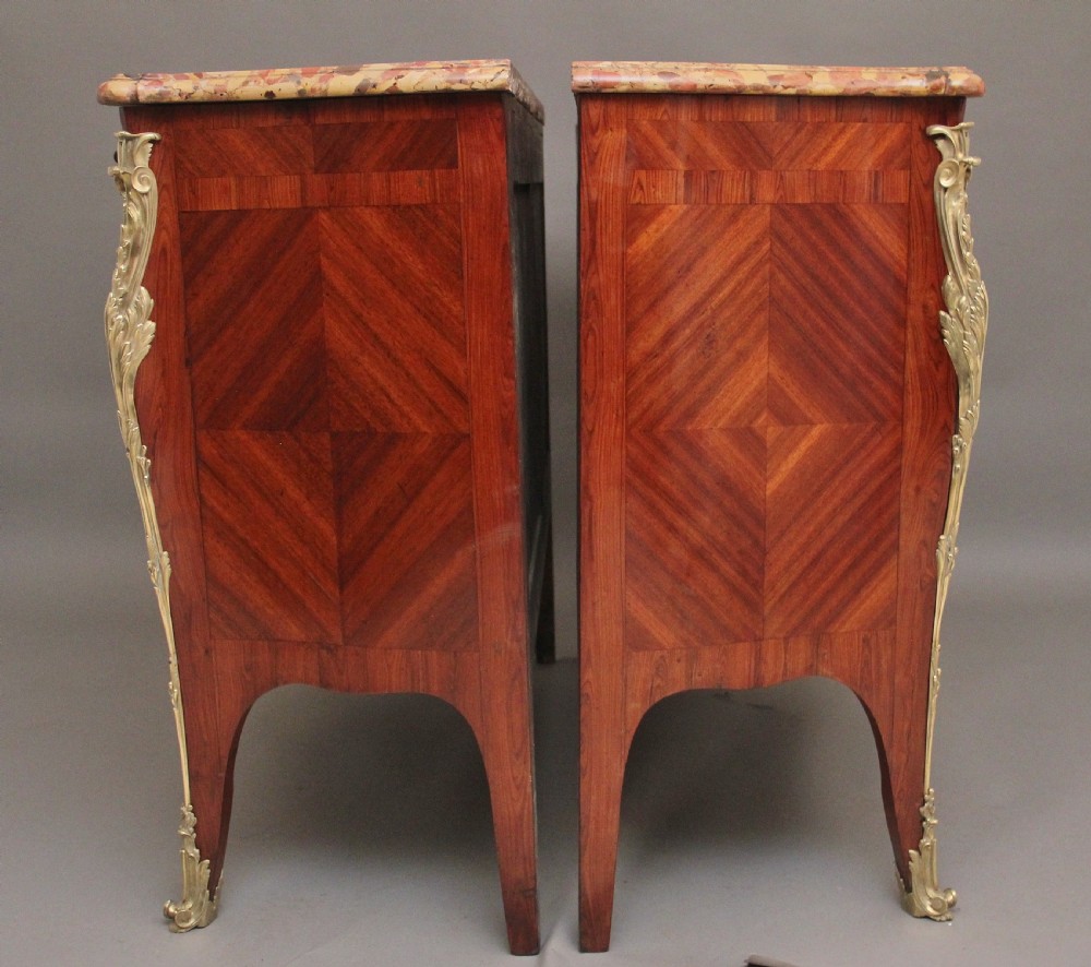 A matching pair of 19th-century French kingwood commodes featuring herringbone parquetry veneer, gilt bronze mounts, and fitted marble tops. View VII