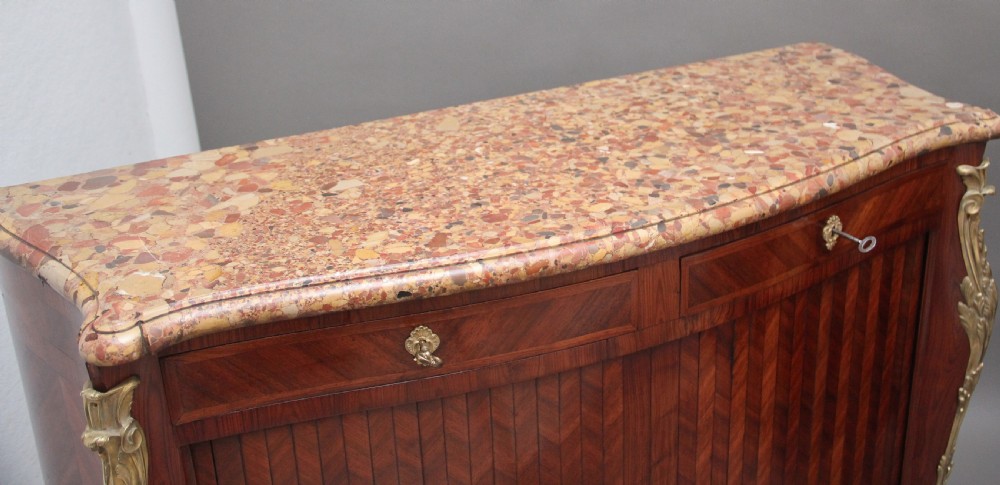 A matching pair of 19th-century French kingwood commodes featuring herringbone parquetry veneer, gilt bronze mounts, and fitted marble tops. View VIII