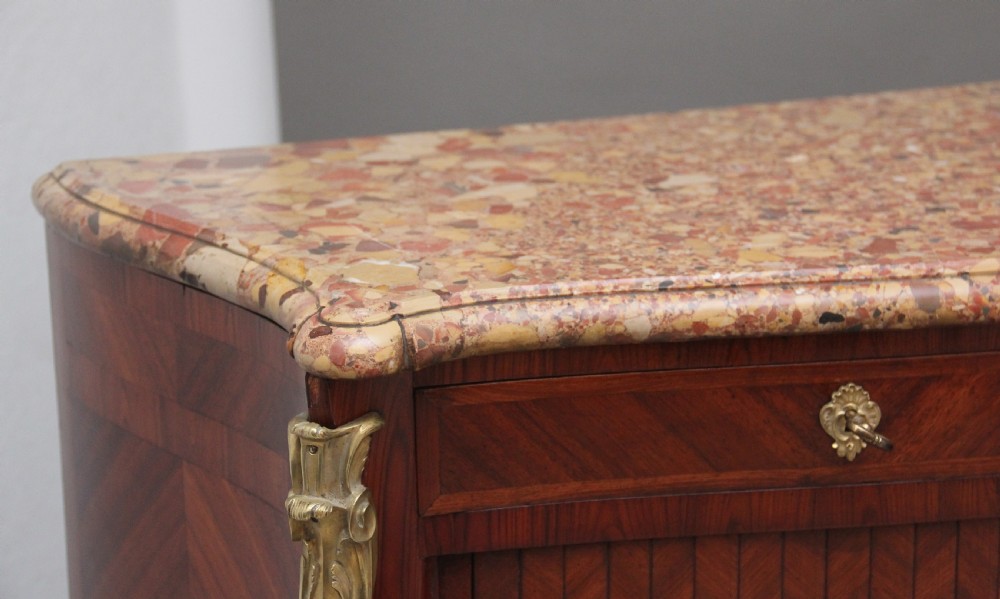 A matching pair of 19th-century French kingwood commodes featuring herringbone parquetry veneer, gilt bronze mounts, and fitted marble tops. View X