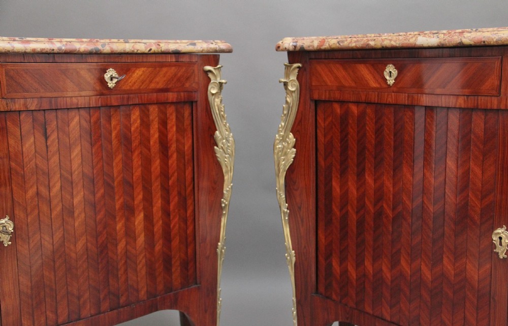 A matching pair of 19th-century French kingwood commodes featuring herringbone parquetry veneer, gilt bronze mounts, and fitted marble tops. View XI