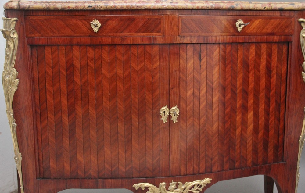 A matching pair of 19th-century French kingwood commodes featuring herringbone parquetry veneer, gilt bronze mounts, and fitted marble tops. View XIII