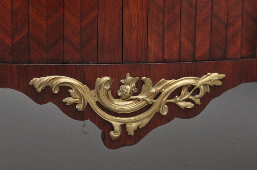 A matching pair of 19th-century French kingwood commodes featuring herringbone parquetry veneer, gilt bronze mounts, and fitted marble tops. View XIV
