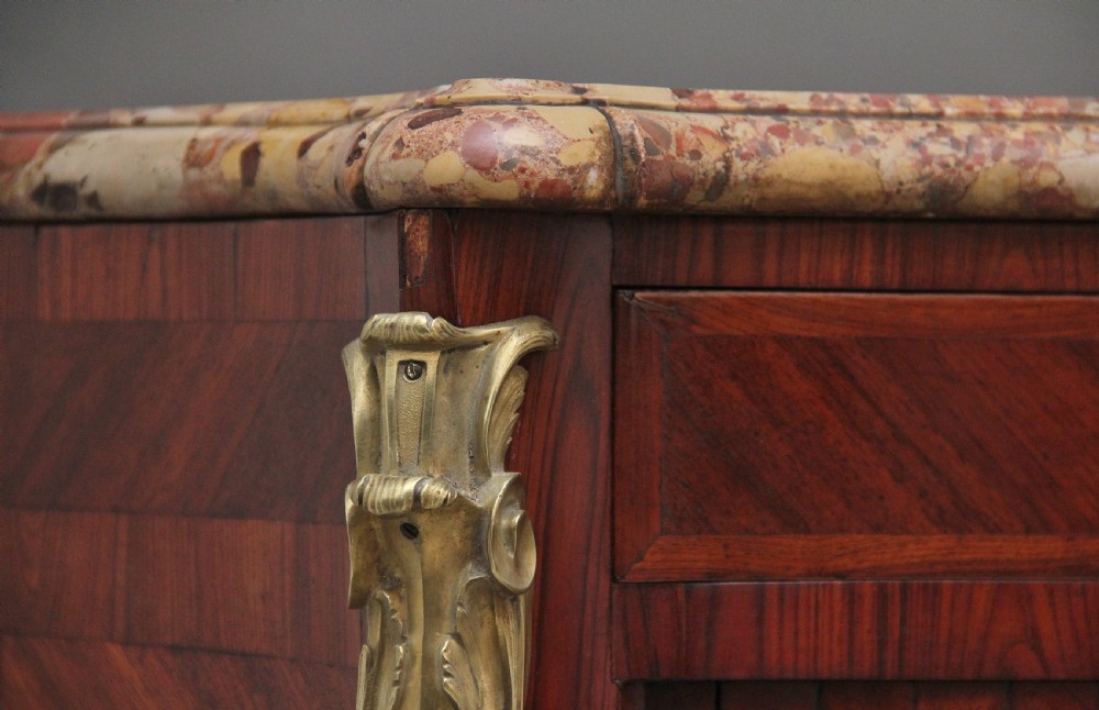 A matching pair of 19th-century French kingwood commodes featuring herringbone parquetry veneer, gilt bronze mounts, and fitted marble tops. View XV