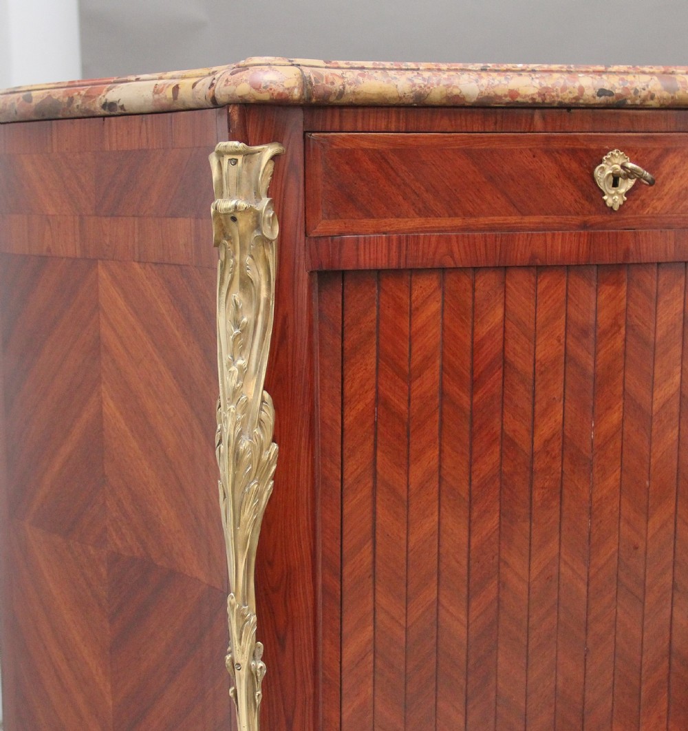 A matching pair of 19th-century French kingwood commodes featuring herringbone parquetry veneer, gilt bronze mounts, and fitted marble tops. View XVI