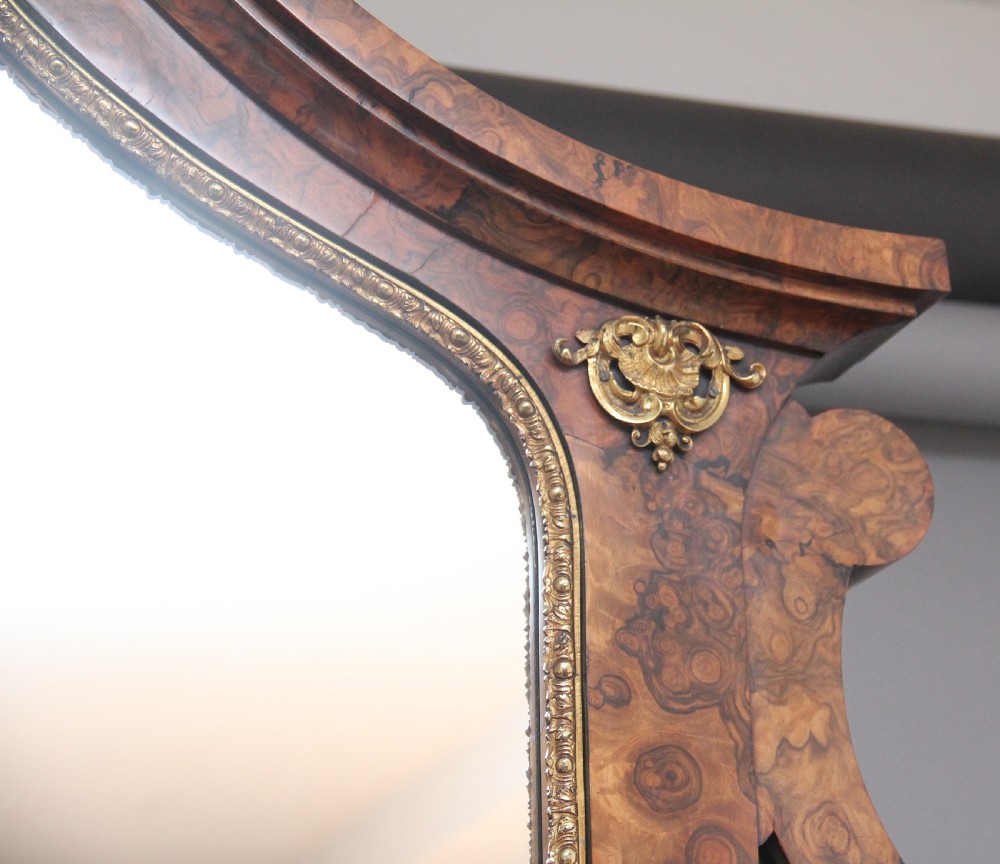 A 19th-century burr walnut credenza with an arched mirror back, ornate gilt-bronze mounts, open tier side shelving, and a central glazed compartment. View VIII
