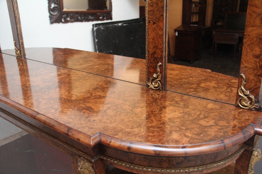 A 19th-century burr walnut credenza with an arched mirror back, ornate gilt-bronze mounts, open tier side shelving, and a central glazed compartment. View XIII