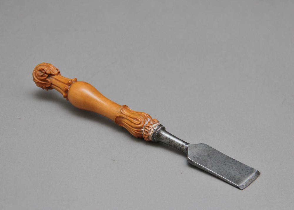 A 19th-century ceremonial set featuring an intricately hand-carved wooden mallet with foliate motifs and a matching carved wooden-handled steel chisel. View III