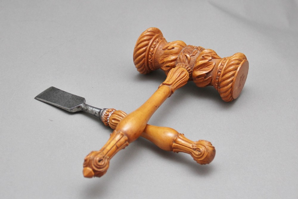 A 19th-century ceremonial set featuring an intricately hand-carved wooden mallet with foliate motifs and a matching carved wooden-handled steel chisel. View VIII