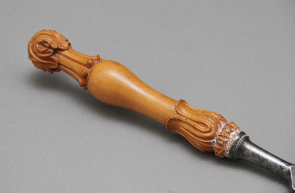 A 19th-century ceremonial set featuring an intricately hand-carved wooden mallet with foliate motifs and a matching carved wooden-handled steel chisel. View XI