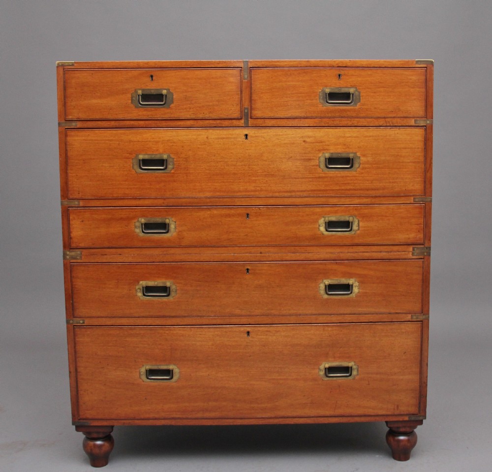 A nineteenth-century mahogany military secretaire chest in two sections with brass corners, flush brass handles, turned feet, and an extended writing drawer. View II