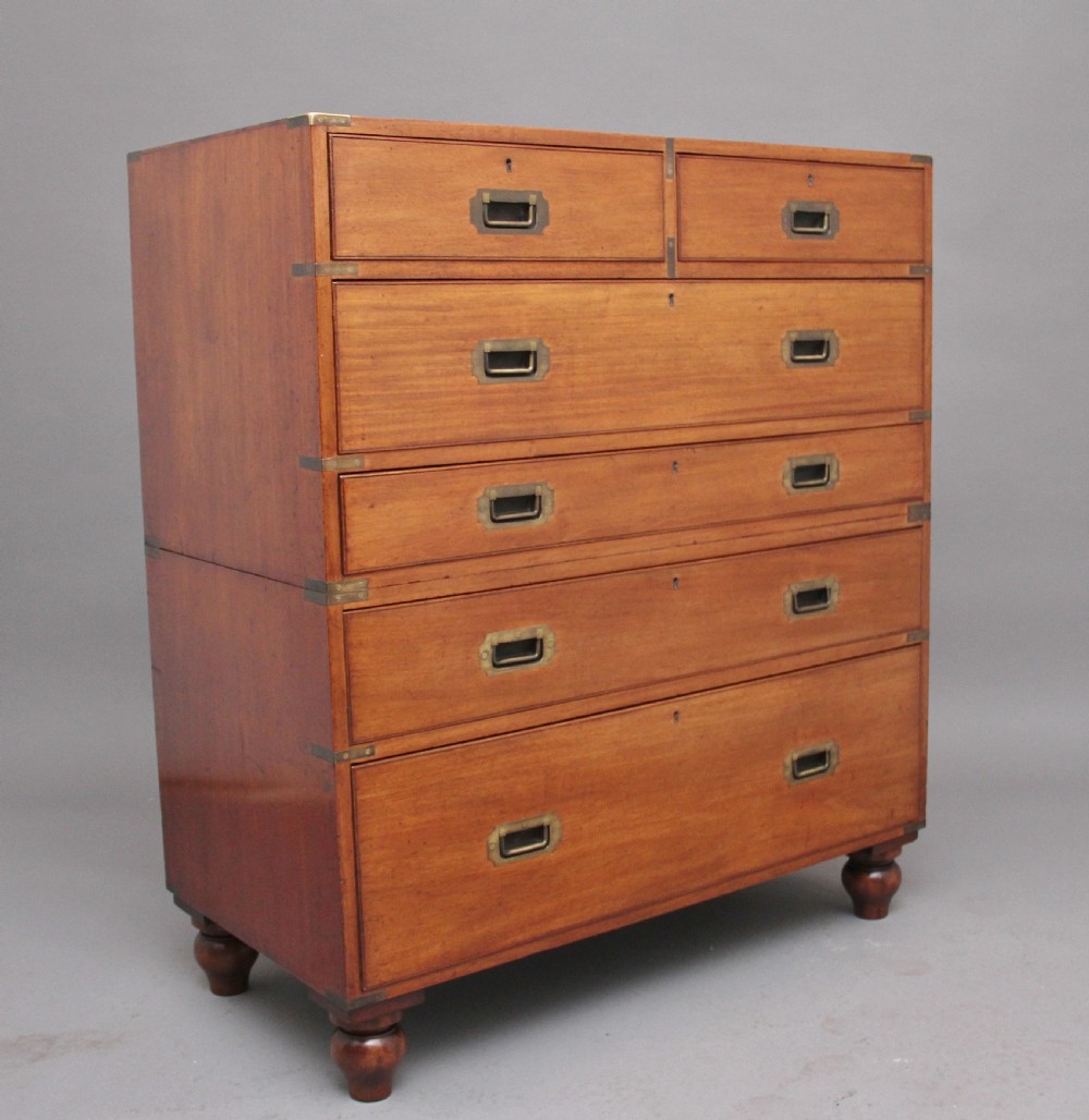 A nineteenth-century mahogany military secretaire chest in two sections with brass corners, flush brass handles, turned feet, and an extended writing drawer. View III