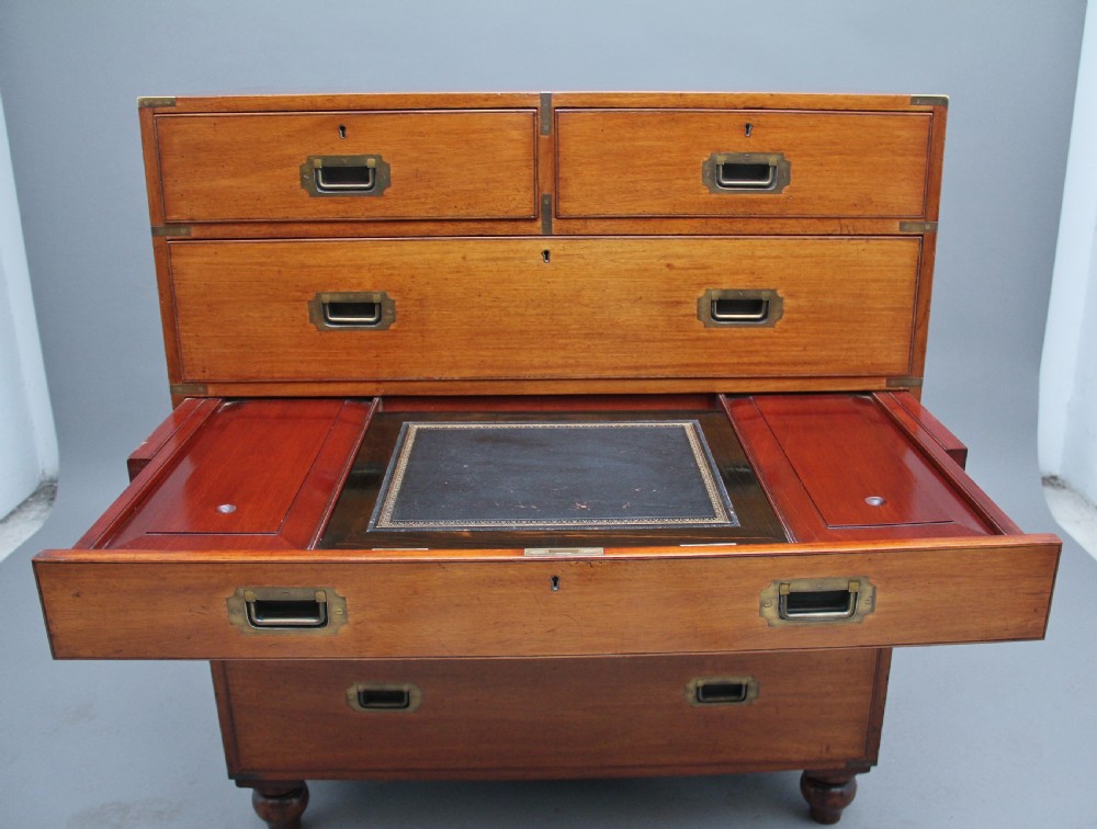 A nineteenth-century mahogany military secretaire chest in two sections with brass corners, flush brass handles, turned feet, and an extended writing drawer. View IX