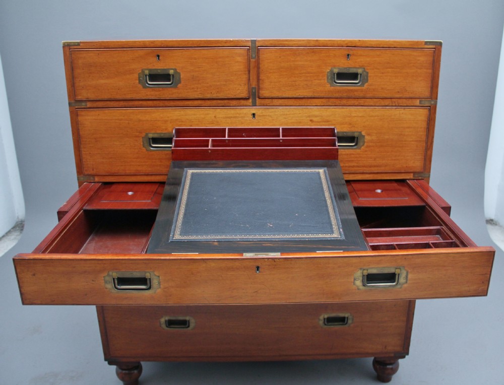 A nineteenth-century mahogany military secretaire chest in two sections with brass corners, flush brass handles, turned feet, and an extended writing drawer. View XI