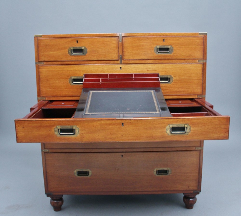 A nineteenth-century mahogany military secretaire chest in two sections with brass corners, flush brass handles, turned feet, and an extended writing drawer. View XII