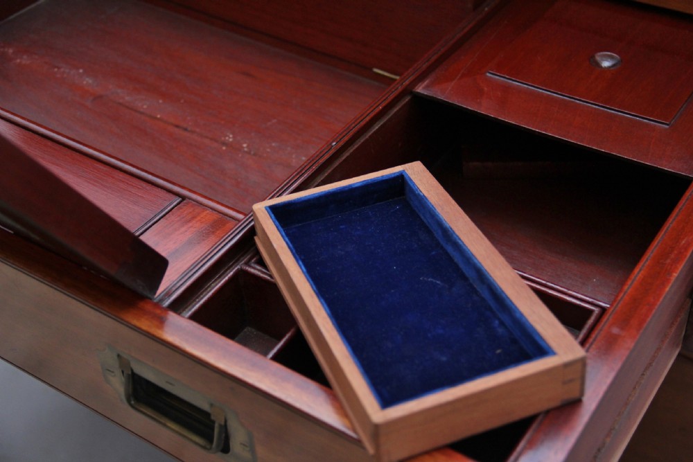 A nineteenth-century mahogany military secretaire chest in two sections with brass corners, flush brass handles, turned feet, and an extended writing drawer. View XV