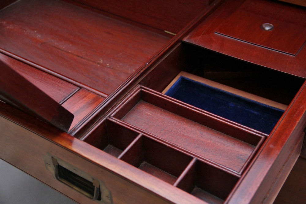 A nineteenth-century mahogany military secretaire chest in two sections with brass corners, flush brass handles, turned feet, and an extended writing drawer. View XVI