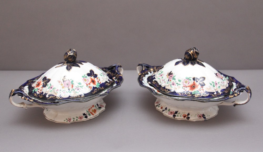 A pair of 19th-century white and cobalt blue ironstone tureens featuring hand-painted floral decoration, gilt accents, moulded handles, and flower bud finials. View II