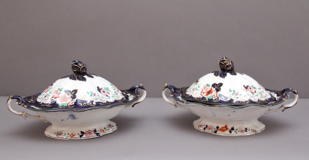 A pair of 19th-century white and cobalt blue ironstone tureens featuring hand-painted floral decoration, gilt accents, moulded handles, and flower bud finials. View VI