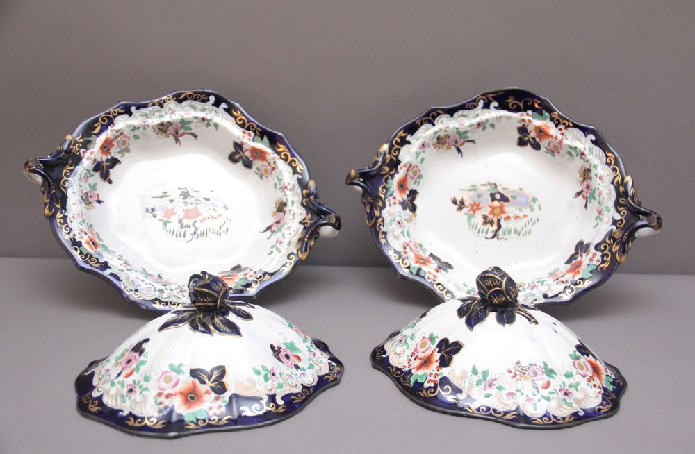 A pair of 19th-century white and cobalt blue ironstone tureens featuring hand-painted floral decoration, gilt accents, moulded handles, and flower bud finials. View IX