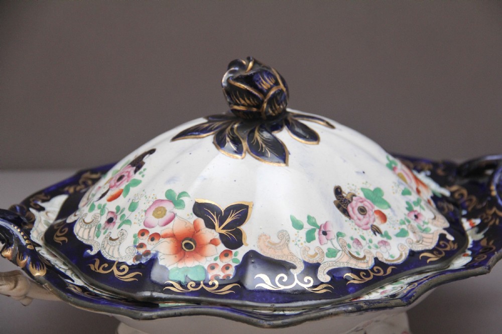 A pair of 19th-century white and cobalt blue ironstone tureens featuring hand-painted floral decoration, gilt accents, moulded handles, and flower bud finials. View XII