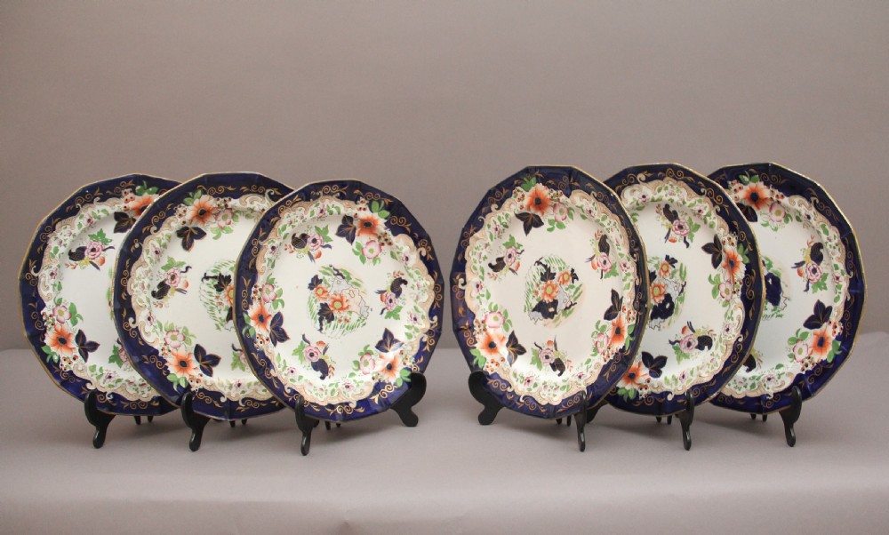 A set of six octagonal 19th-century Masons ironstone plates featuring cobalt blue borders, orange and pink floral transfer motifs, and gilt highlights.
