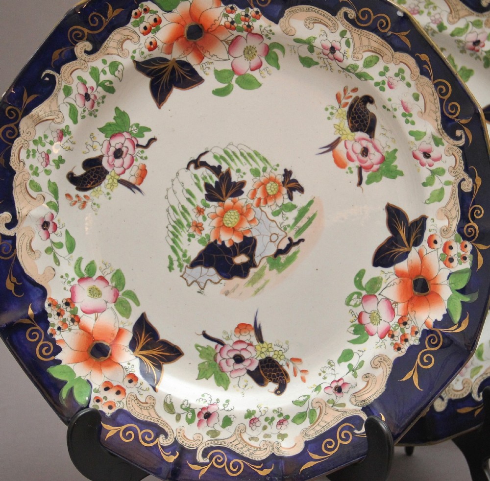 A set of six octagonal 19th-century Masons ironstone plates featuring cobalt blue borders, orange and pink floral transfer motifs, and gilt highlights. View III