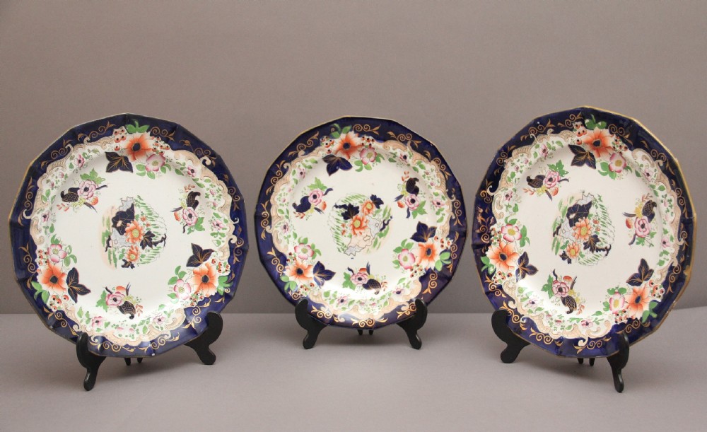 A set of six octagonal 19th-century Masons ironstone plates featuring cobalt blue borders, orange and pink floral transfer motifs, and gilt highlights. View VII