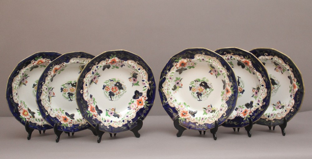 A set of six octagonal 19th-century Masons ironstone soup bowls featuring dark blue borders with gold scrollwork and hand-painted floral motifs.