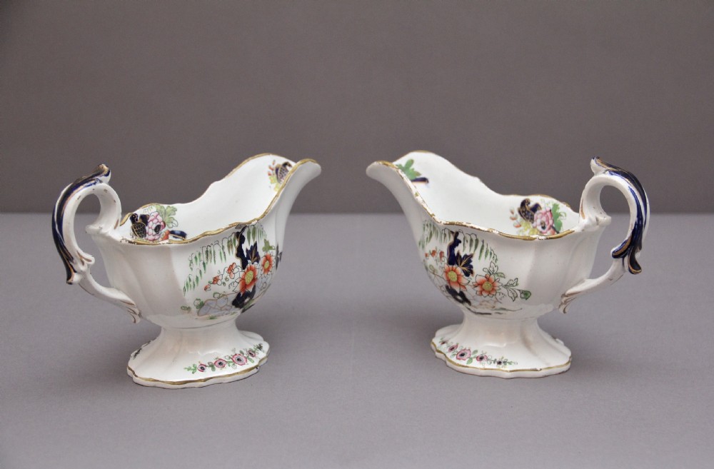 A pair of early nineteenth-century white porcelain sauceboats decorated with hand-painted floral motifs, cobalt blue accents, and gilded scalloped rims. View III